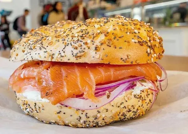 Hand-sliced lox piled on a bagel