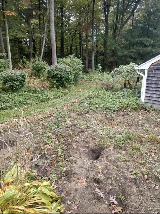 Side yard in Massachusetts cleared to bare dirt by E'Bros for ground prep
