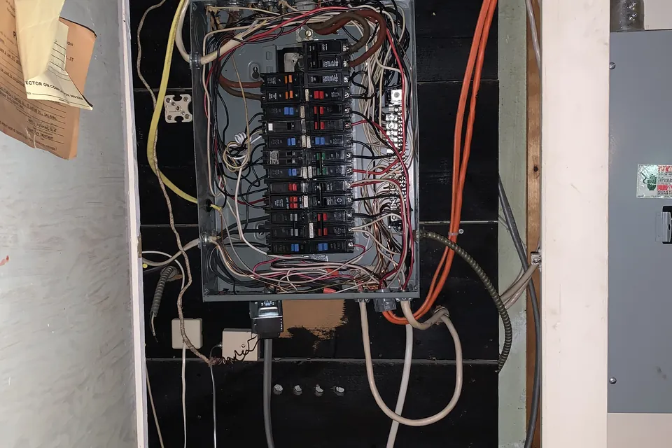 Old tangled electrical panel before replacement by Gourley Electric