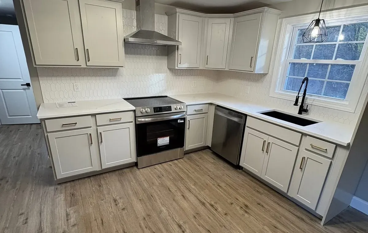 Remodeled white kitchen with a new chandelier and pendant lighting wired by Gourley Electric