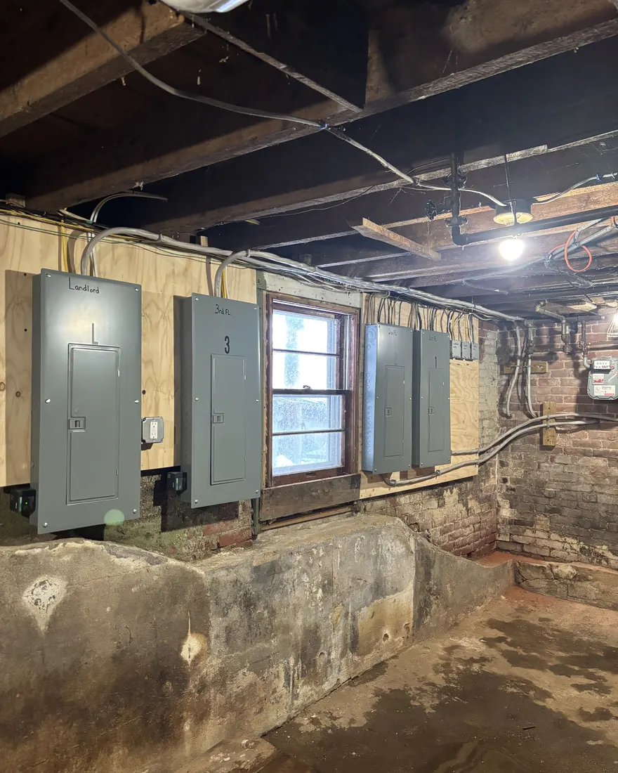 Clean row of labeled electrical sub-panels mounted on a new backboard by Gourley Electric in Worcester MA