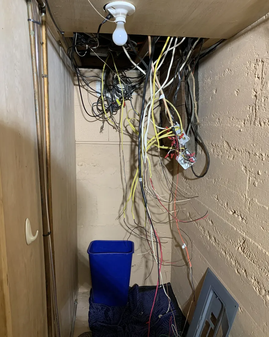 Same closet mid job with the old panel removed and wiring hanging loose during a panel replacement