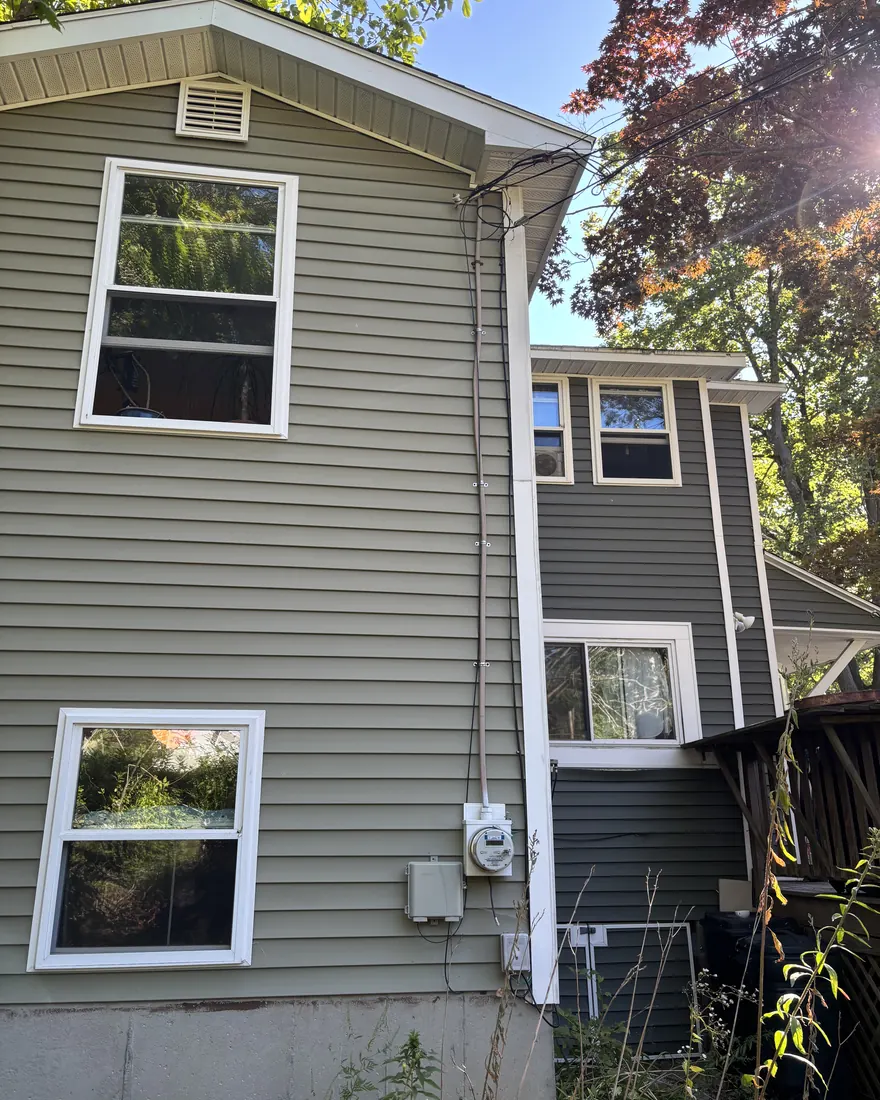 Aging overhead electrical service drop and meter socket on the side of a Worcester area home before upgrade
