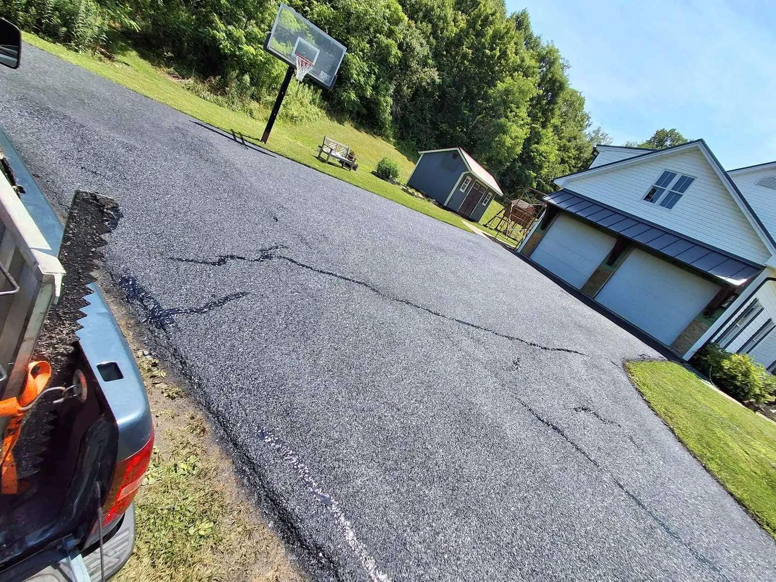 Damaged residential asphalt driveway with cracks ready for Keith's hot tar crack filling and sealcoating