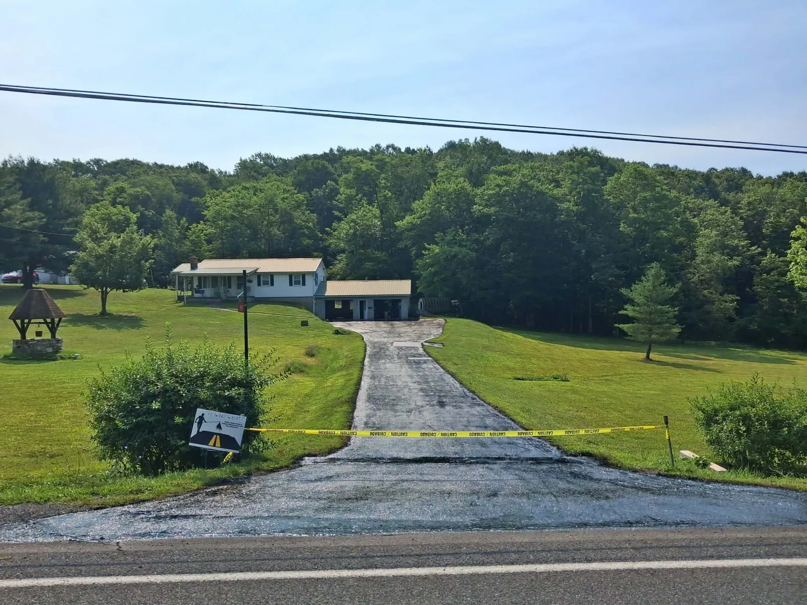 Long rural residential driveway sealcoated by Keith's Sealcoating with dark protective finish