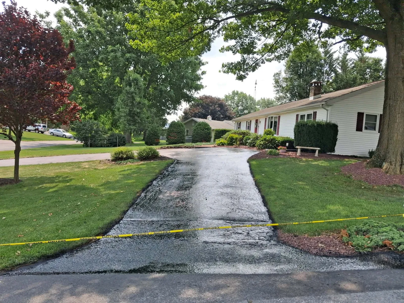 Residential home with professionally sealcoated asphalt driveway from Keith's Sealcoating